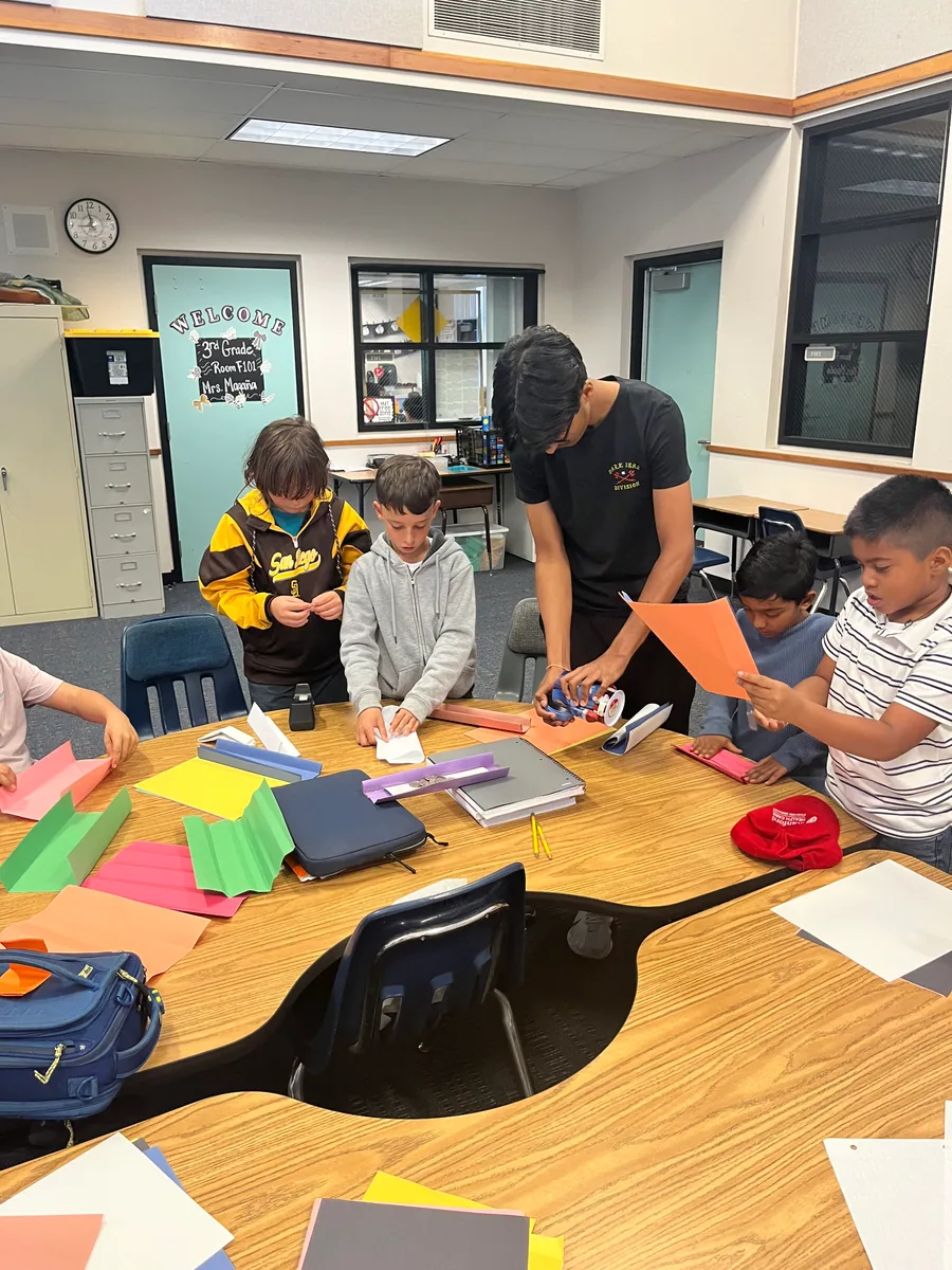 Curious Engineers volunteers helping elementary students build a hands-on project
